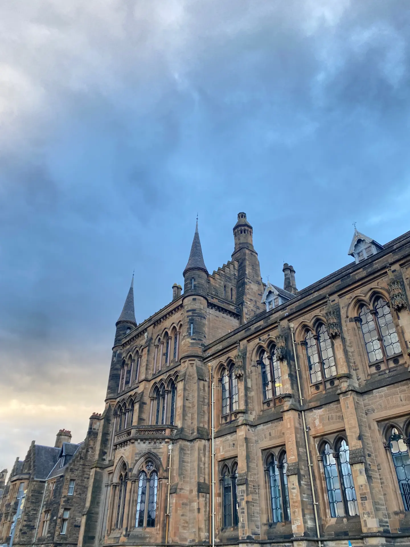 Bâtiment universitaire néogothique à Glasgow sous un ciel nuageux